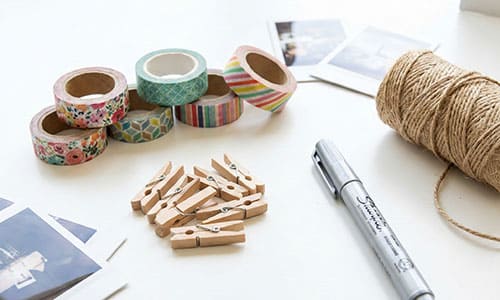 Flat lay of washi tape, wooden clips, and twine for photo display