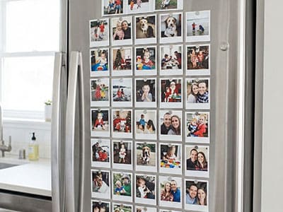 Fridge door covered in a grid of mini square photo magnets