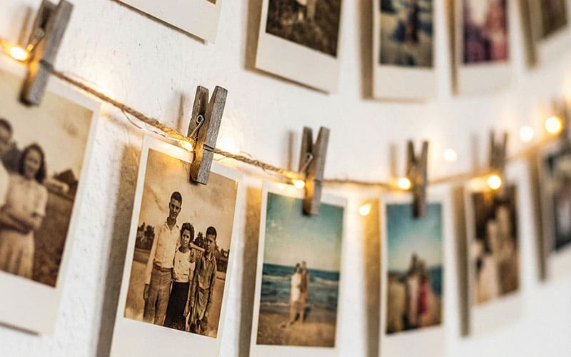 Photos hanging on twine with fairy lights