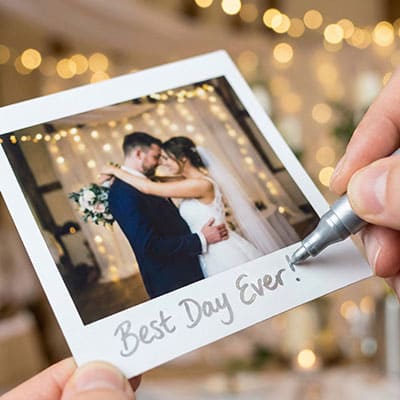 Hand writing a message on the wide border of an instant photo