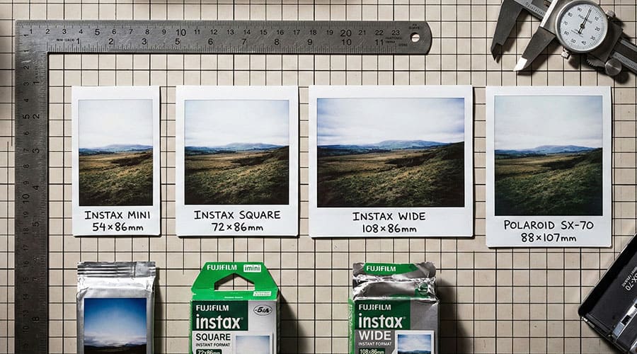 Comparison of Instax Mini, Square, Wide and Classic Polaroid photo sizes on a wooden table