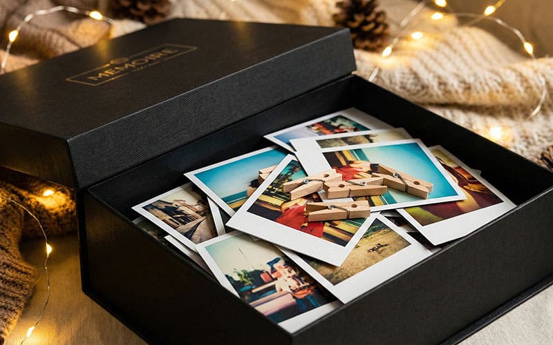 Open black box filled with photos and wooden pegs