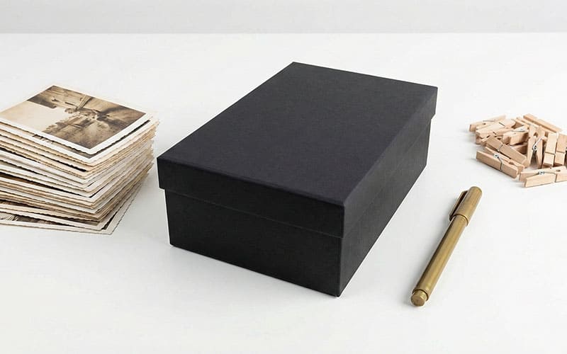 Flat-lay of photo box supplies: photos, box, wooden clips